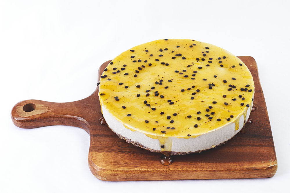 
            
                Load image into Gallery viewer, Passionfruit cheesecake on a wooden board
            
        